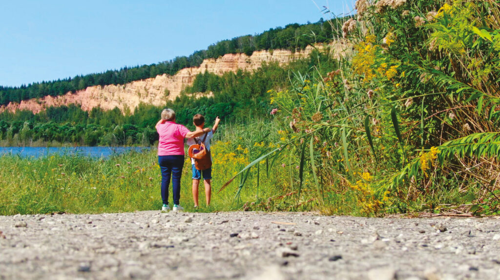 Femme et enfant debout de dos devant un paysage de carrière de grés